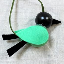 Closeup of green beaded bird necklace