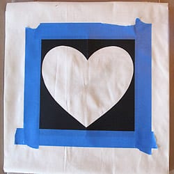 Heart stencil taped on pillow cover.