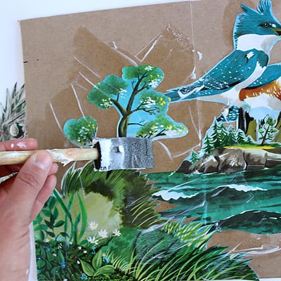 An image detailing using a foam brush to modge podge The Little Island illustrations to the medium weight craft paper.